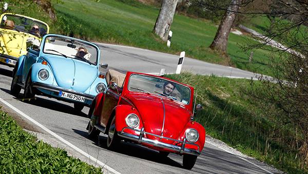 Red, blue and yellow VW Beatle driving on a road