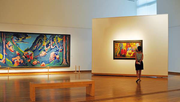 Woman standing in Museum hall looking at a painting