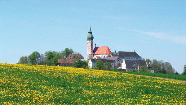 Andechs monastery in front of green lawn with yellow flowers