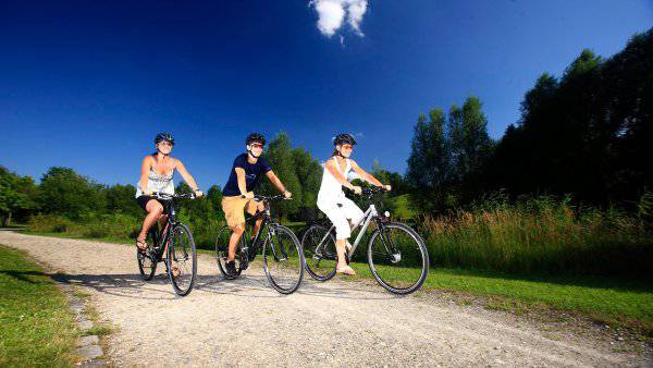 Drei Radfahrer fahren auf Feldweg