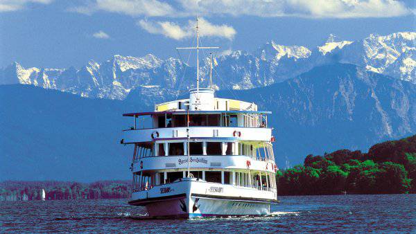 Ausflugsschiff auf dem See vor Alpenkulisse