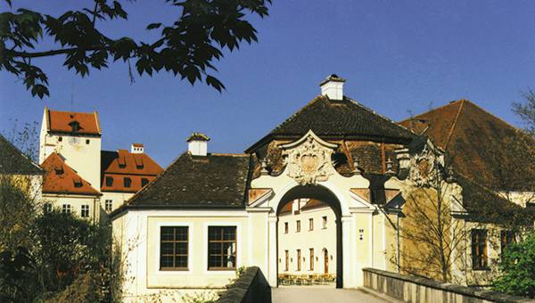 Eingang von Schloss Seefeld mit Gebäuden im Hintergrund