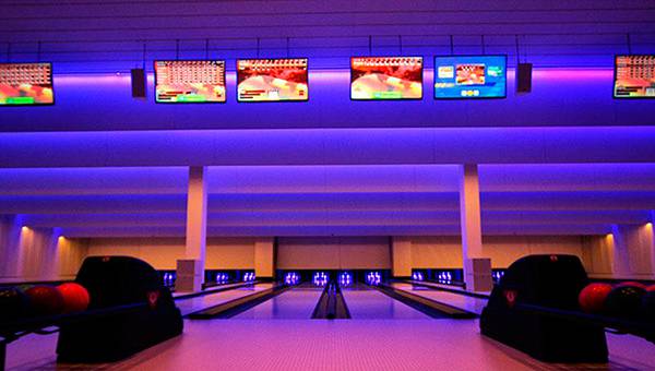 Bowling alley with flatscreens and blue lighting