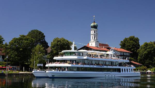 Tourist ferry on a Lake in front of classic Bavarian church