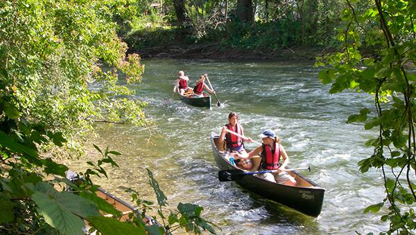 Two canoes with two people each floating on river Amper