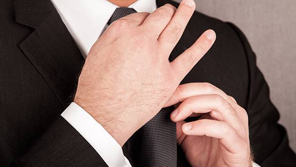 Man in suit fixing his tie