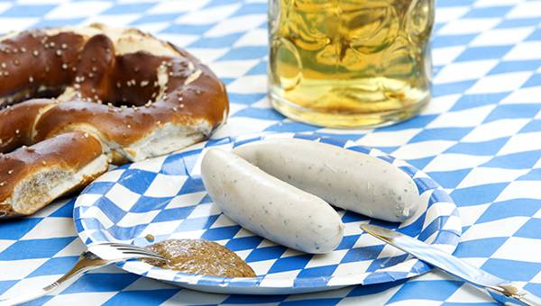 Pretzel, beer and German sausage on a table