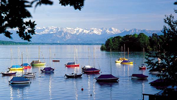 Colourful sail boats on Lake Starnberg with view of the Alps