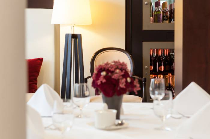 Table set in Restaurant Oliv's with flowers and wine shelf