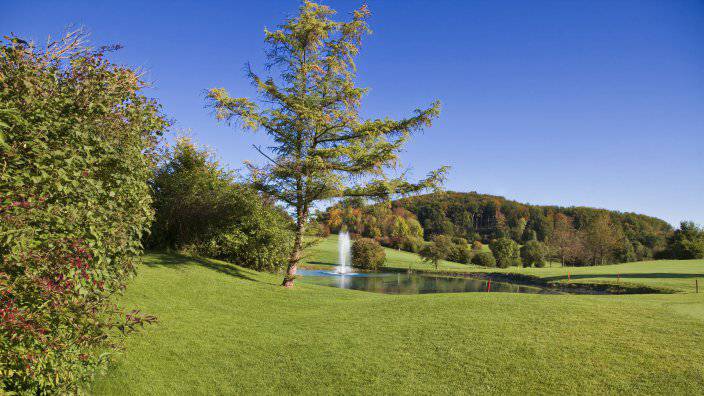 Carefully laid out golf course with small pond